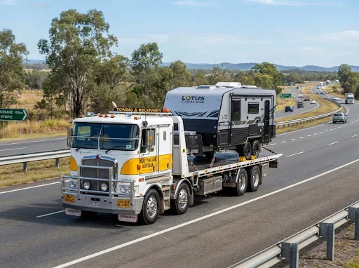 Illustration of a caravan carried on a truck along a regional road